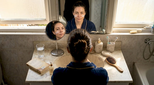 Woman applies moisturizer as part of morning skincare